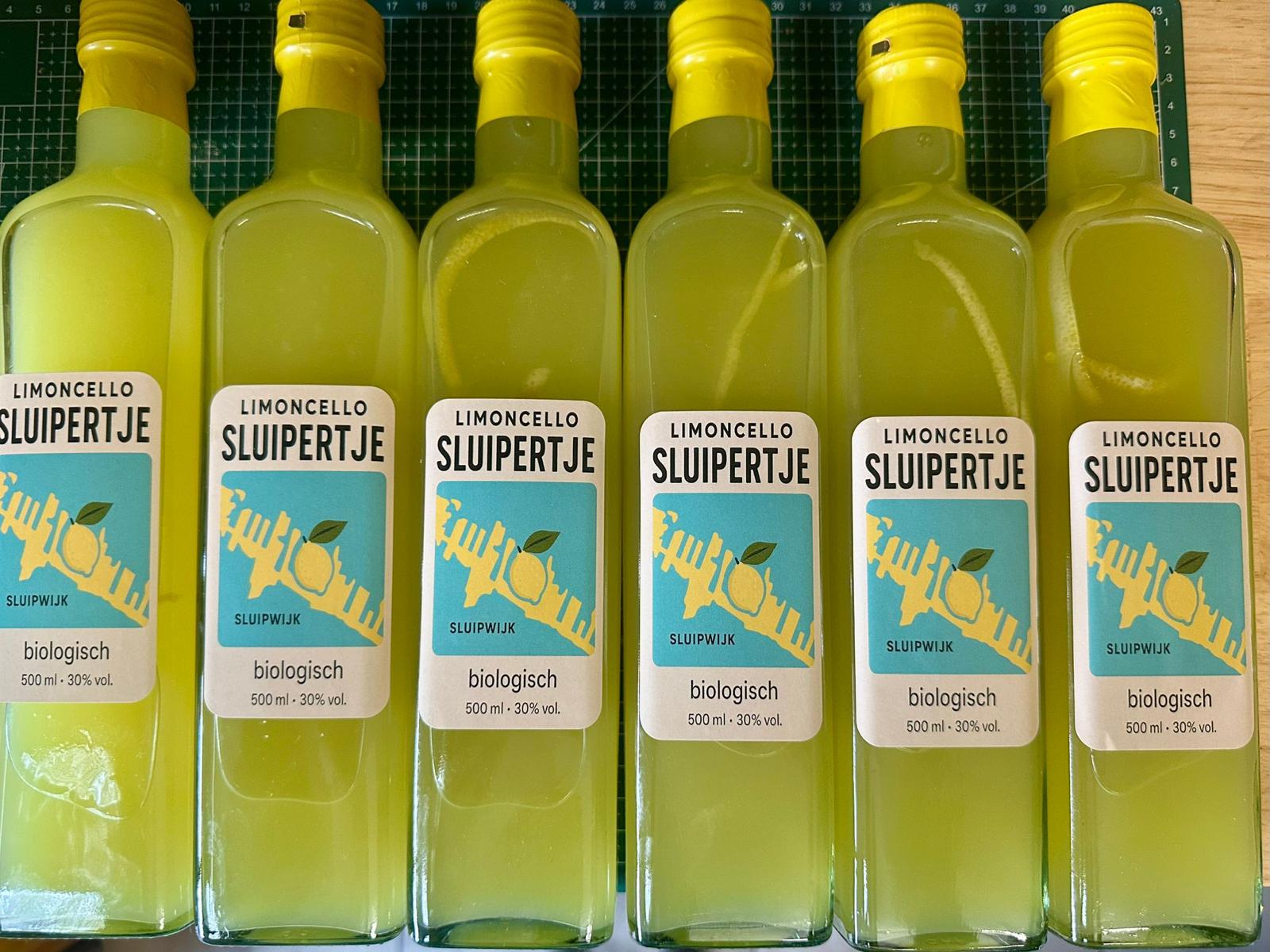 Rij afgevulde flessen Limoncello Sluipertje met kraftpapieren etiket, klaar voor verzending